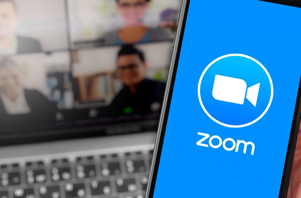 ライブ配信しているビジネスマンとZOOMが表示されたスマートフォン